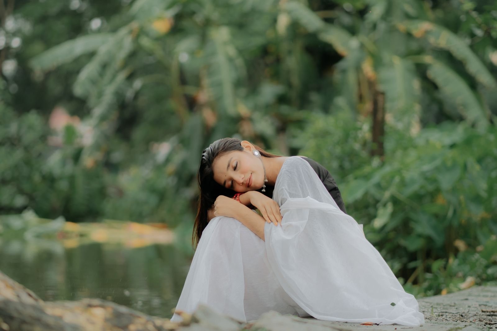 A woman relaxing outdoors by the water, at ease