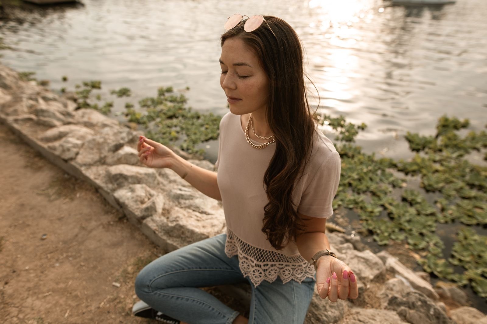 A woman taking a quiet, reflective moment outdoors by the water