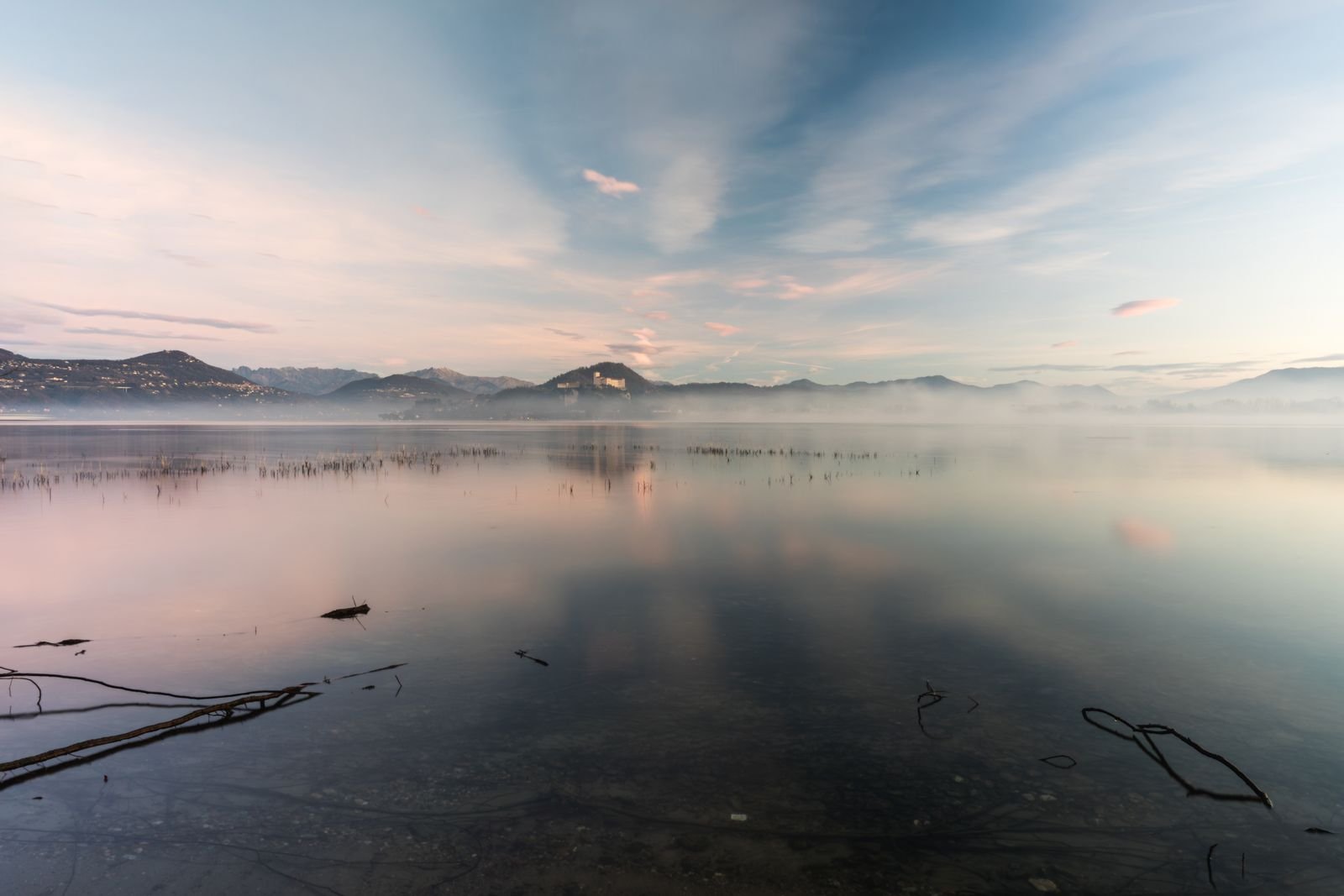 A calm, misty lake at sunrise